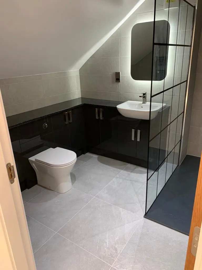 Run of black gloss bathroom units with white basin and grey porcelain floor