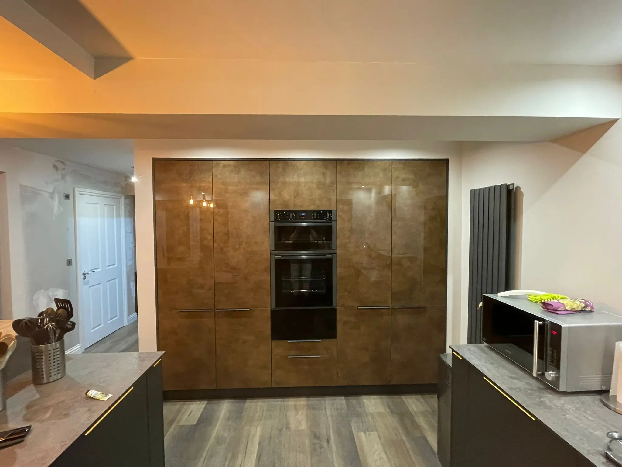 Bronze-patina tall units housing built-in double ovens and microwave