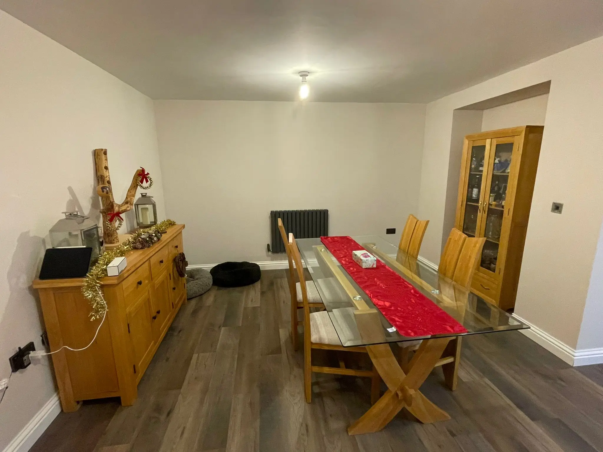 Dining room with glass-top oak table, oak dresser and grey wood-effect floor