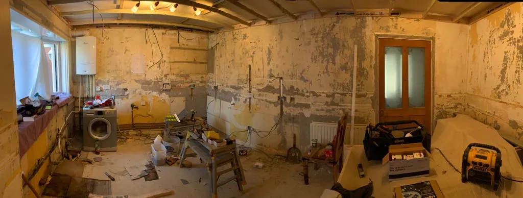 Panoramic view of a kitchen stripped back to bare walls ready for first fix