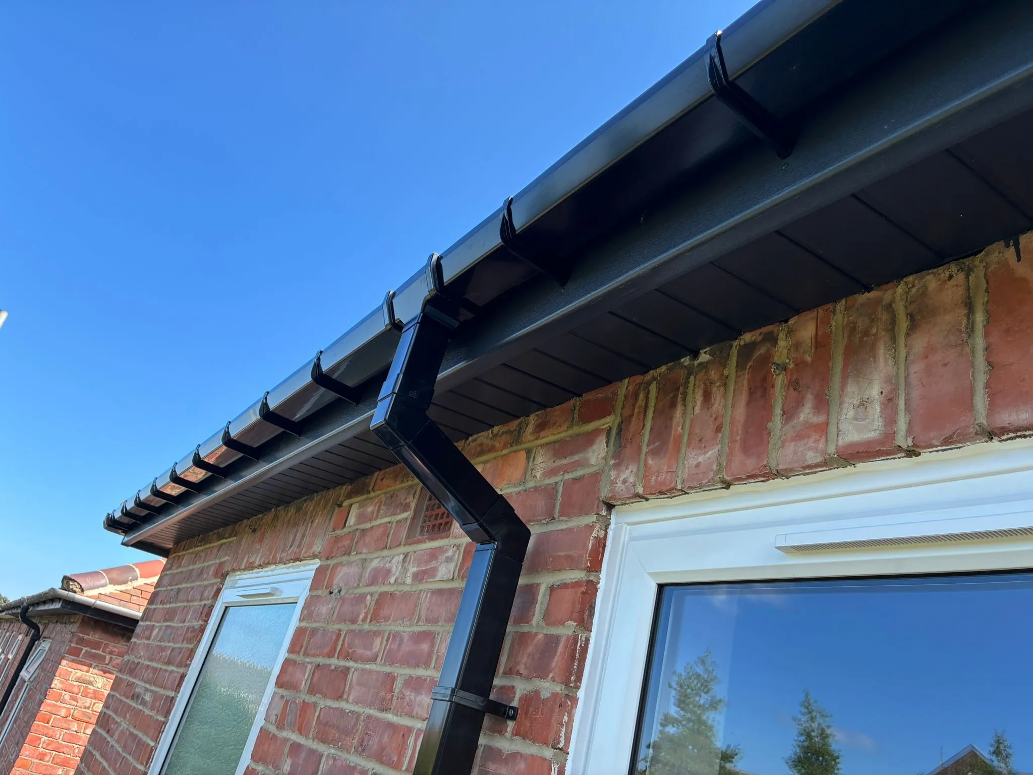 New anthracite fascia, soffit and guttering against blue sky