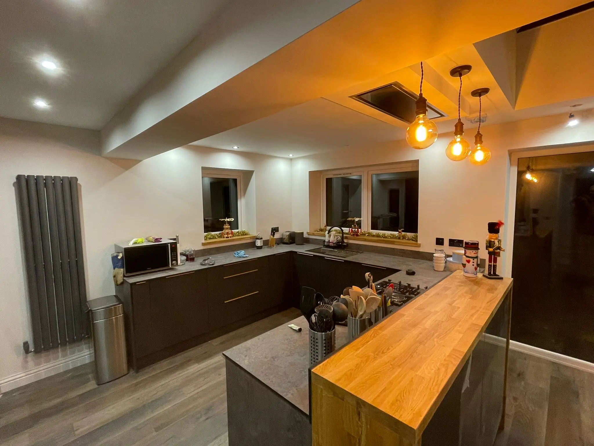 Oak breakfast bar and charcoal units with an anthracite vertical radiator