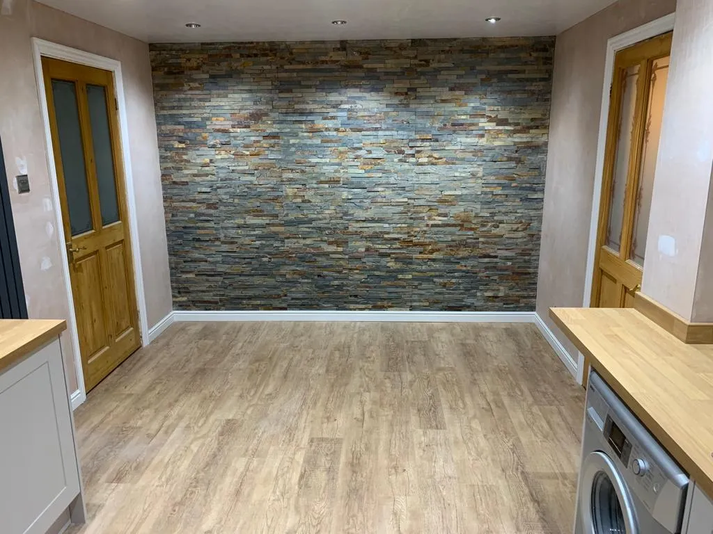 Boot room with natural slate feature wall, oak worktops and pink plaster ready for decoration